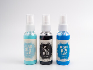 Vials of acrylic spray paint on a white background. Close-up.