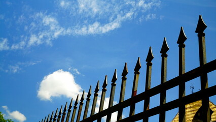 Railing with decorative anti-climb points seen from below and in lateral perspective with blue sky