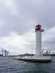 Fototapeta na wymiar Seascape Sea with lighthouse, calm water and white clouds
