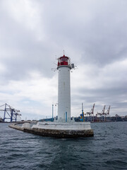 Seascape Sea with lighthouse, calm water and white clouds