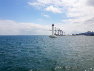 Fototapeta na wymiar Seascape Sea with lighthouse, calm water and white clouds