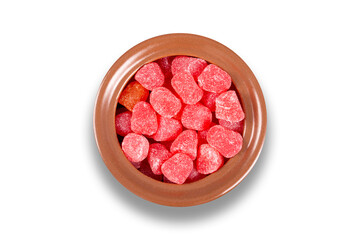 Red candy in bowl isolated on white background. Top view