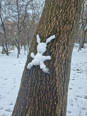 Snow rabbit on a tree trunk