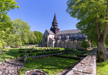 Varnhem Abbey Church with ruins or overgrown arches and graveyard in Vastra Gotaland, Sweden.