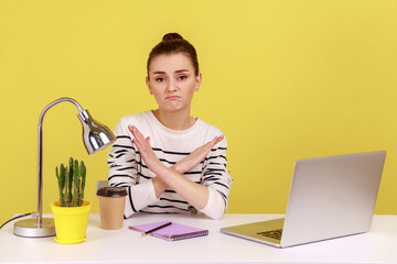 Upset sad woman manager worker sitting at workplace crossing hands showing x sign, rejecting and...