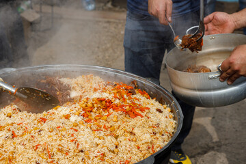 Stirring the pilaf in a large bowl during cooking outdoors.