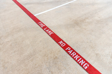 Fire lane no parking marking on the asphalt of a parking lot, tow away zone, red fire lane painted...
