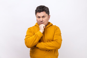Hmm, i'm need thinking. Portrait of middle aged man looking up, holding chin and musing, looking at...