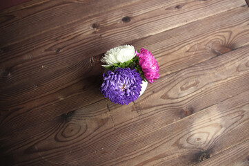 bouquet of colorful aster flowers on wooden table
