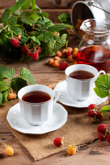 Tea with raspberry on a wooden table. Useful drink for health. Traditional medicine.
