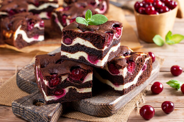 Chocolate cheesecake layered with brownie and dark cherrie. Chocolate cherrie cake. Pieces of chocolate cake. Traditional american cuisine.