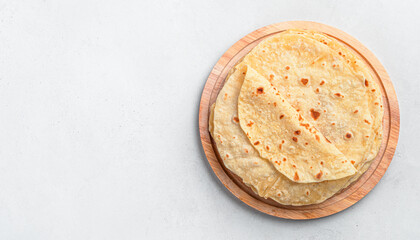 Indian chapati cakes on a wooden board on a gray background. Traditional Indian food. Top view, copy space