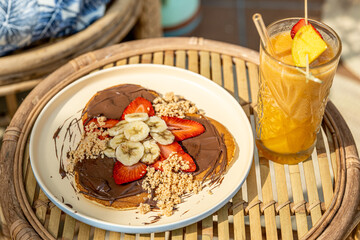 Delicious pancakes with sweet strawberries, banana and chocolate 