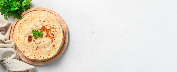 Traditional Indian flatbreads with fresh herbs on a gray background. Top view, copy space