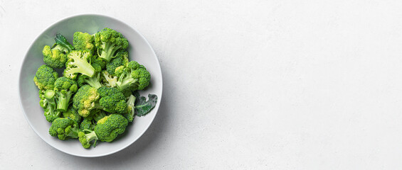 Ripe broccoli sliced in a gray plate on a light background. Healthy food. Top view, place to copy