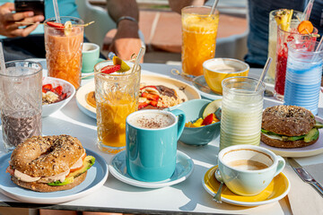 Friends enjoying healthy breakfast, delicious pancakes with sweet strawberries, banana and chocolate 