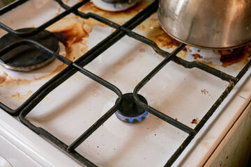 Dirty home cooking stove, natural look. The gas stove is burning with a blue flame. 
