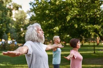 Fototapeta premium Concentrated man with blur friends practicing yoga