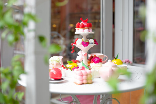 Sweet sugar strawberry dessert treats on white table in cafe or candy shop outdoors. Opening of new bakery or restaurant