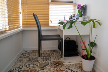 modern workplace: chair near table desk with laptop, stationery, orchid plant, open white textbook with pen. Concept of work, work from home, study, back to school, home office