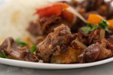 Focus on a piece of meat in a dish with guinea pig on a table