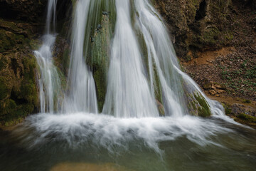 Fototapeta premium Beautiful waterfall splashing over mossy rocks