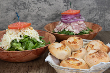 Italian food feast is set up on the table with two salads to choose from or a basket of garlic and cheese rolls