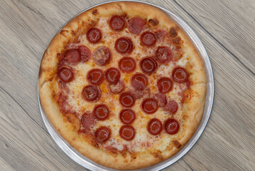 Overhead view of hot from the oven is a crispy crust Italian baked pepperoni pizza that is ready to eat