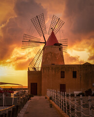 Vertical shot of Saline of Trapani and Pacheco, Italy, during a beautiful orange sunset - obrazy, fototapety, plakaty