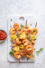 kebab skewers of barbecued shrimp with a pineapple