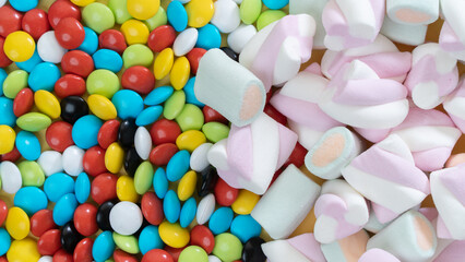 Fototapeta na wymiar Background of marshmallows and colorful dragees, sweets