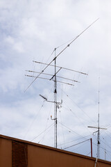 Image of an amateur radio antenna on top of a tall building in a city