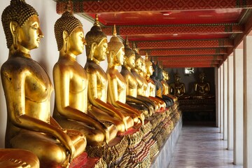 Row of Buddha statues lined up at Wat Pho temple in Bangkok, Thailand.