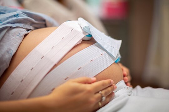 A woman waiting in the delivery room at the hospital. Stress test and monitoring baby’s heart beat and contractions.