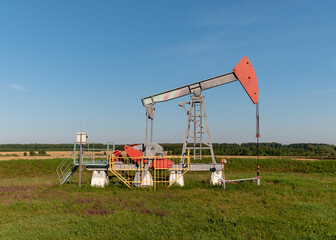 Fototapeta na wymiar Operating oil and gas well in oil field, profiled against the blue sky