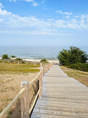 Empty path and wooden walkway to the beautiful beach on a summer day. Scenic coastal landscape with the ocean in the background. Photo taken at Stenshuvud national park in Skåne, Sweden.