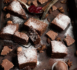 Baked square pieces of chocolate brownie sprinkled with powdered sugar
