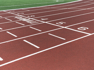 Red treadmill at the stadium with white lines