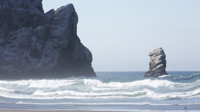 Cinemagraph of big rock at Morro Bay in California on sandy beach
