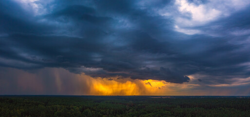Fototapeta na wymiar Storm cloud in the sunset light, aerial drone panorama of a storm