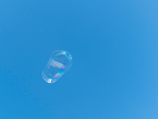 Soap bubble flying against the blue sky