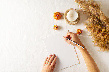 Autumn and winter checklist goals and woman hands, candle and dry pampas grass
