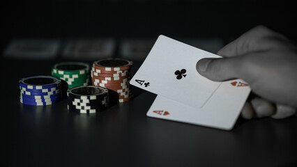 Obraz premium Dealer or croupier shuffles poker cards in a casino on the background of a table, chips. Concept of poker game, game business. Playing for money, a big win, a jackpot, gambling, a desire to get rich