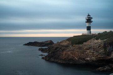 Fototapeta na wymiar Pancha island lighthouse at sunset in Ribadeo coast, Lugo province, Galicia, Spain