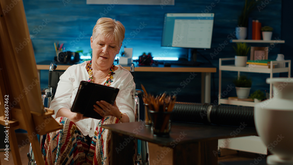Poster wheelchair user with health condition using tablet to find inspiration on internet to draw masterpie