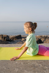 A girl doing yoga on the beach early in the morning.