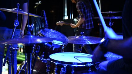 Drummer playing drums at stage, close up. Music concert. Drummer on festival with band under the stage lights. Drummer playing drum kit in nightclub at live rock concert. Music instrument. - Powered by Adobe