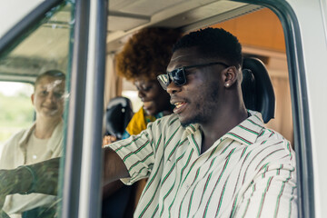 Afro-American man with his friends driving a van, medium closeup outdoors trip concept. High quality photo