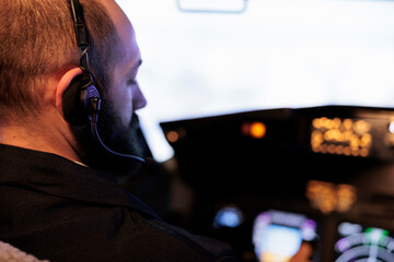 Male pilot using airplane cockpit command to fly jet, pushing dashboard and control panel buttons....