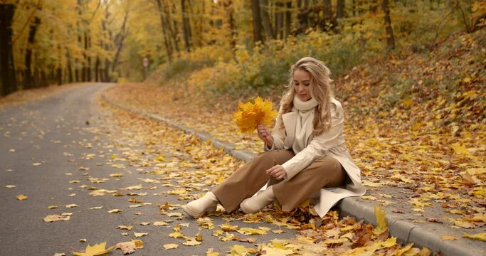 Young woman sitting on the roadside in the park